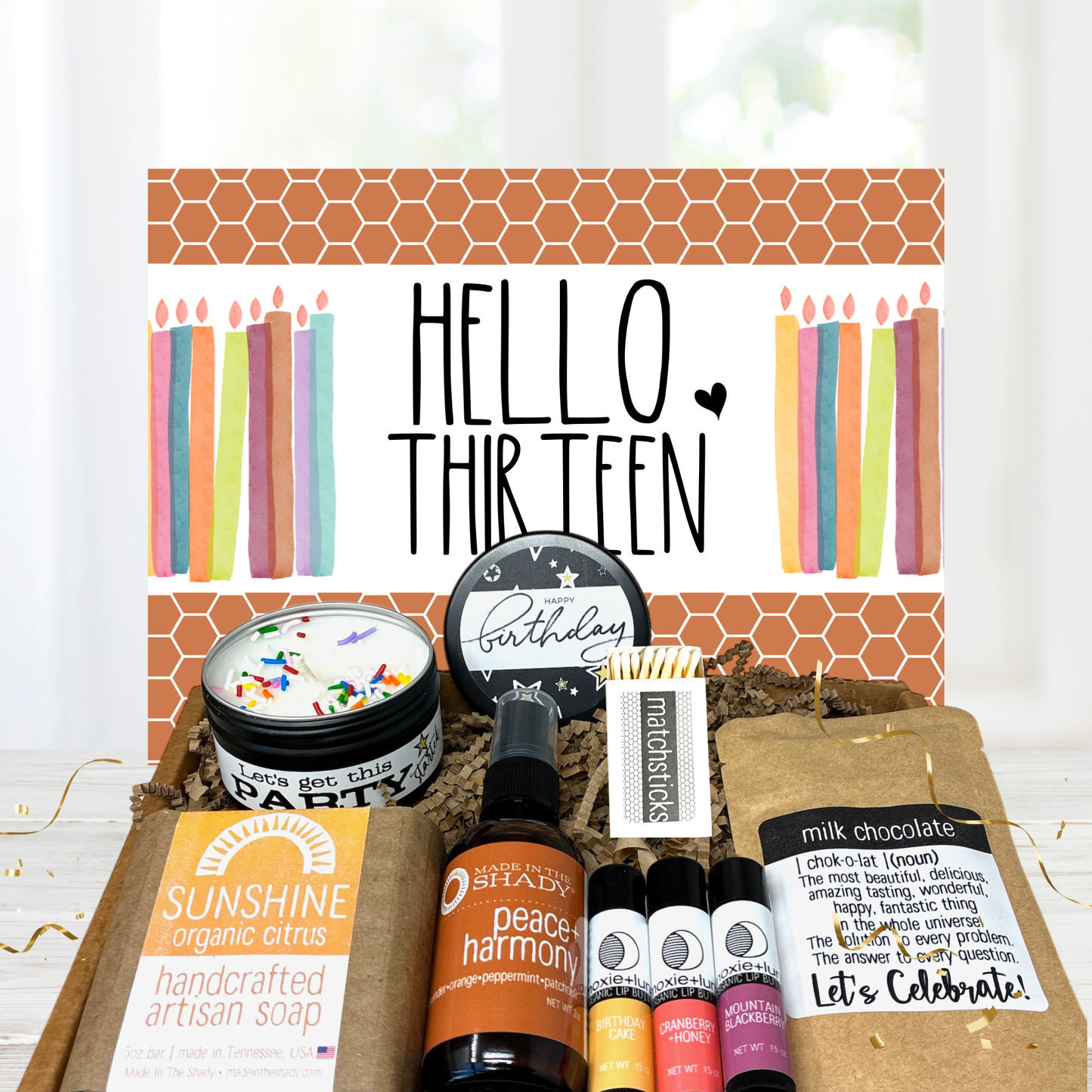 Gift set for a 13th birthday with candles, soap, and other items on a white background.